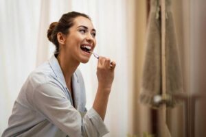 Woman carefully brushing her teeth, demonstrating proper oral hygiene technique
