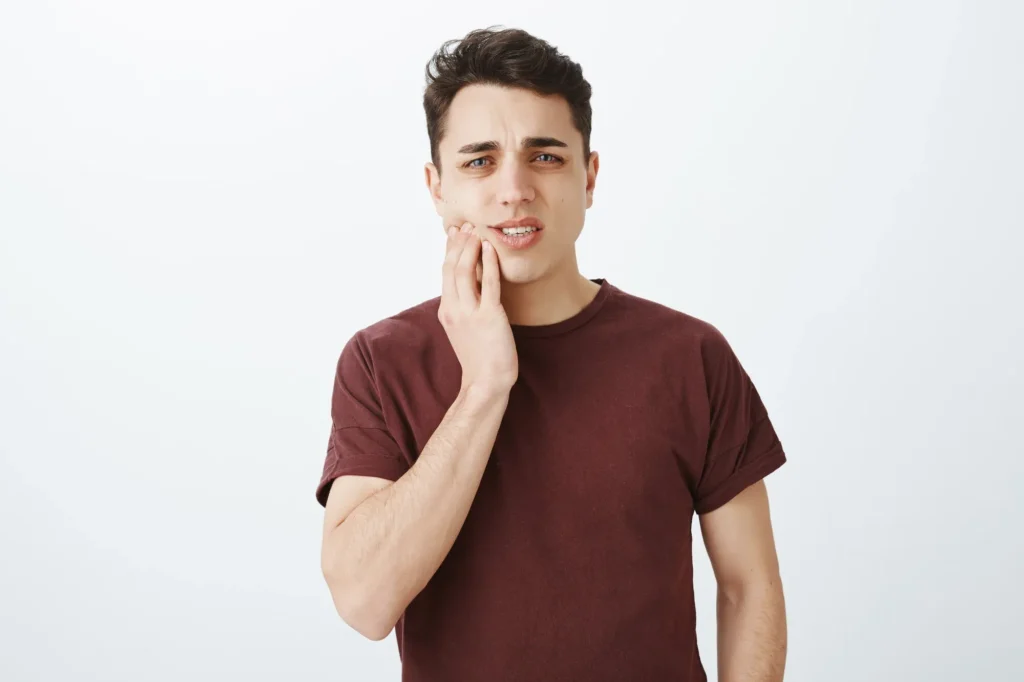 Displeased man in pain from wisdom teeth in Sydney seeking urgent dental care