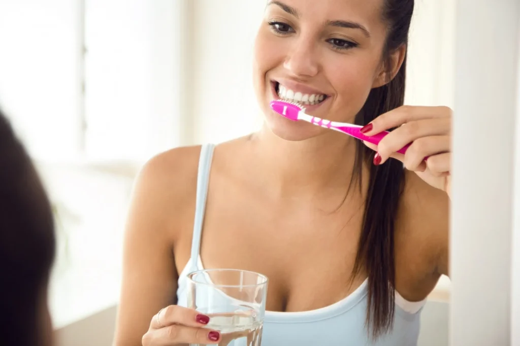 Young woman brushing her teeth preparing for wisdom teeth removal in Sydney